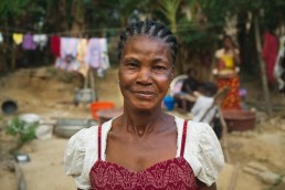 Yvette smiles outside her home in Ivory Coast, as she explains how Mobile Money has improved her life