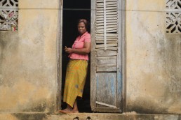 Elyse uses mobile money on her phone at her home in Ivory Coast