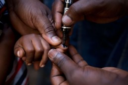A health worker with GAVI marks the fingernail of a child who has been vaccinated against measles and rubella in Tanzania