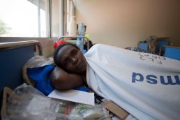 Kitmonga, who suffers from cervical cancer, lies in a hospital bed with Tanzania