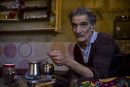 An elderly Syrian refugee makes coffee in Lebanon