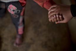 A disabled Syrian refugee boy is helped to walk by his sister in Lebanon