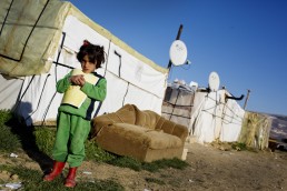 A Syrian refugee girl holds a book in Lebanon